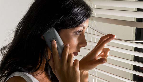 Woman Looking Out Window Blinds
